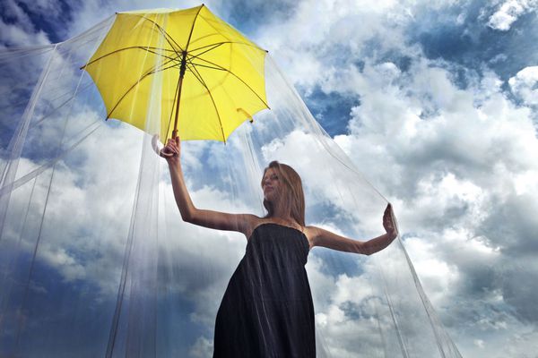 زیبایی رمانتیک با یک چتر زرد روی یک سقف آسمان خراش