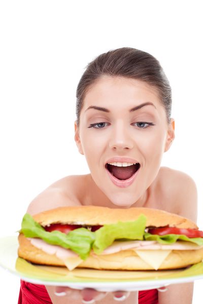 زن شگفت زده در مورد ساندویچ بزرگ ترد بر روی سفید