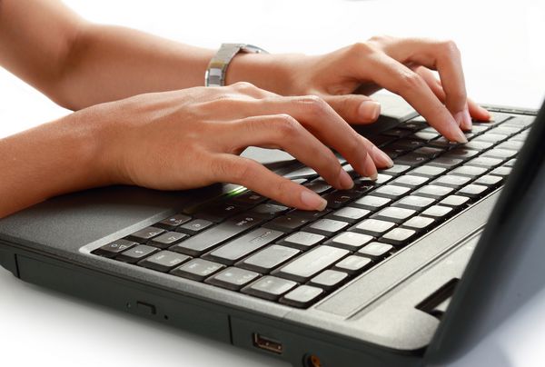 تصویر یک زن جوان تایپ کردن روی لپ تاپ جدا شده در پس زمینه سفید