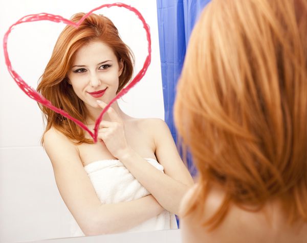 دختر سرخ در نزدیکی آینه با قلب در حمام