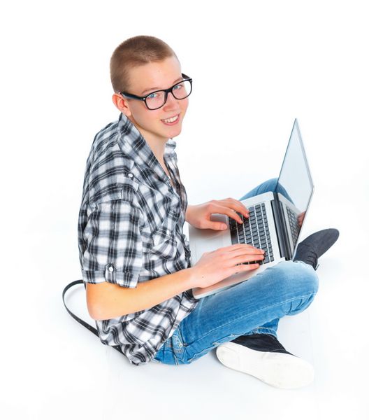 نوجوان نشسته با استفاده از لپ تاپ جدا شده بر روی زمینه سفید