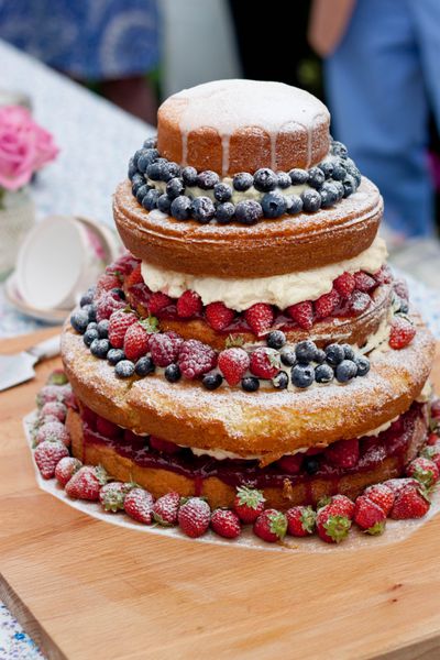 کیک عروسی با زغال اخته و توت فرنگی یک کیک عروسی روستایی بدون علاقه ویترین لایه های کیک و یخ زدگی را نشان می دهد