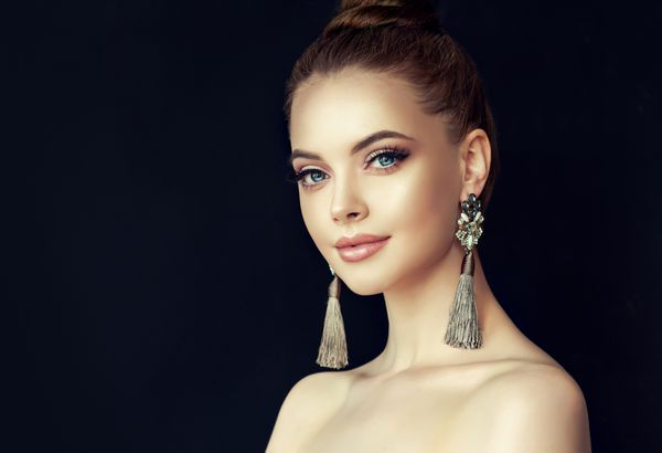 دختر مدل زیبا با مانیکور مروارید روی ناخن ها آرایش و لوازم آرایشی مد گوشواره های بزرگ طوسی جواهرات رنگ خاکستری را نشان می دهد