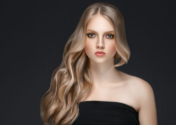مدل موی زیبایی زن بلوند زیبا با آرایش کامل بر روی زمینه سیاه
