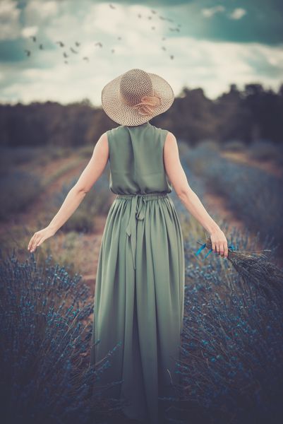 زن با لباس سبز بلند و کلاه در مزرعه اسطوخودوس