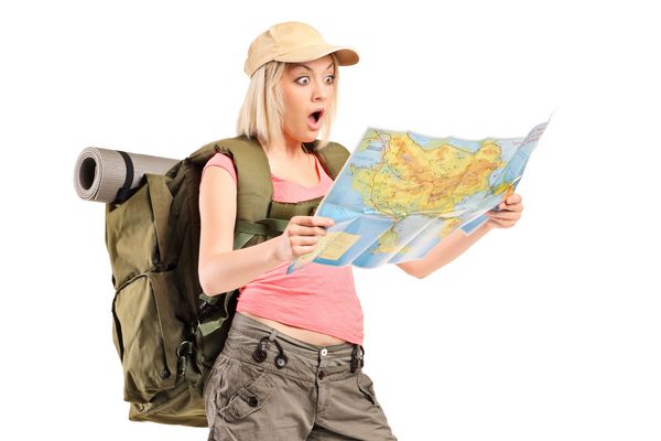 کوهنورد زن شگفت زده که در حال جستجو در یک نقشه است