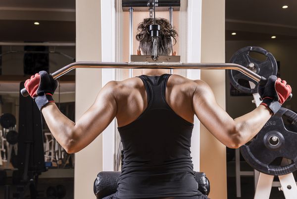 زن جوان ورزشی که عضلات کمر را نشان می دهد