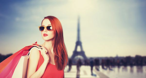 زنان سرخ با کیسه های خرید در پس زمینه پاریسی