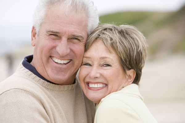 زن و شوهر در ساحل لبخند می زنند