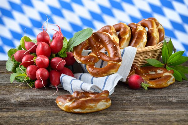 Frische Brezen und Radieschen vor bayerischem wei amp szlig؛ -blauen Rautenmuster