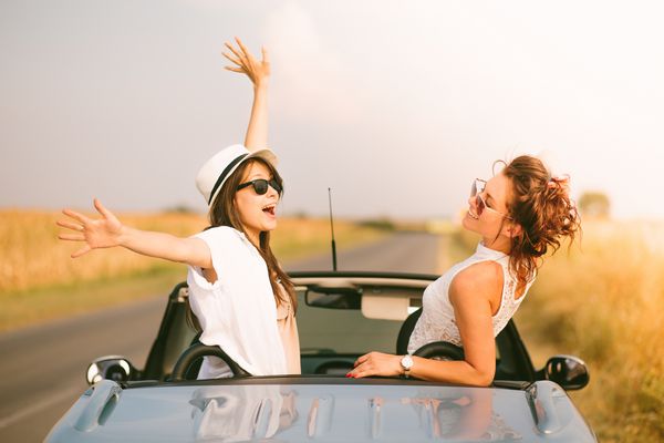 دو دوست دختر از سفر جاده ای در کابریولت خود لذت می برند