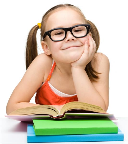 دختر کوچک ناز با عینکی که روی رنگ سفید جدا شده است کتاب می خواند