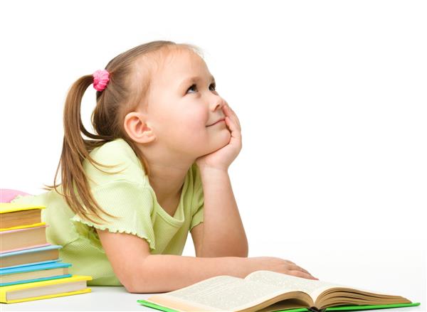 دختر کوچک ناز و سرخوش هنگام خواندن کتاب بر روی زمینه سفید دارز کشیده