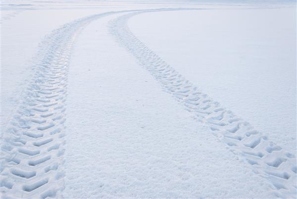 رد پای لاستیک در برف که به سمت افق حرکت می کند