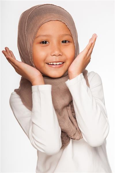 یک دختر کوچک مالایی که روسری خود را به عنوان لباس اسلامی پوشیده است