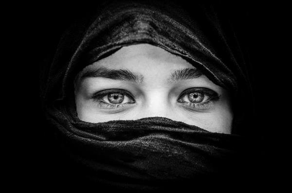 پرتره زن زیبا با چشمان آبی روسری مشکی به رنگ سیاه و سفید