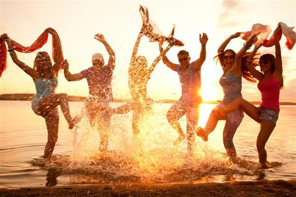 گروه بزرگی از جوانان از یک مهمانی ساحلی لذت می برند