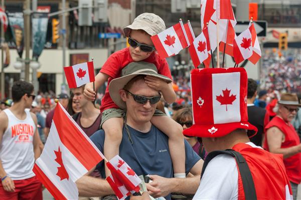 اوتاوا کانادا مردی پرچم های کانادا را برای خانواده خود در روز کانادا در اول ژوئیه 2013 در مرکز شهر اوتاوا انتاریو خریداری کرد