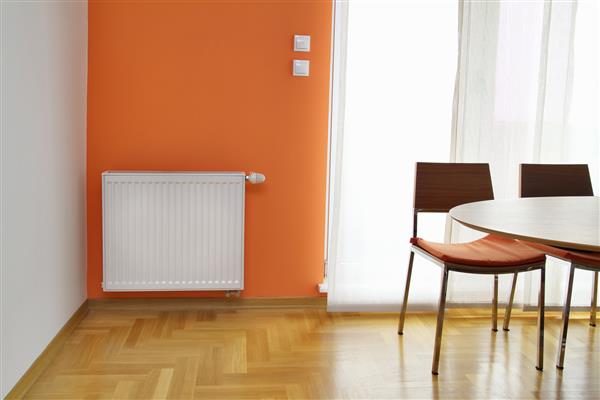 رادیاتور گرم کننده روی دیوار نارنجی