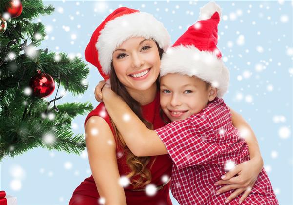 تعطیلات هدیه کریسمس مفهوم مادر و فرزند پسر خوشحال با کلاه های سانتا