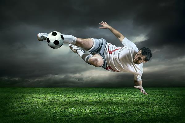 بازیکن فوتبال با توپ در فضای باز عمل می کند