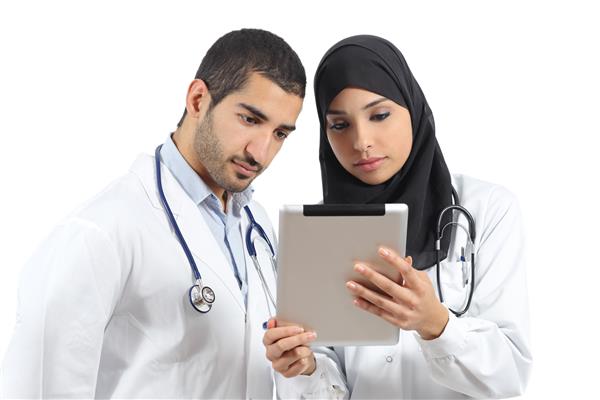 پزشکان عرب سعودی که با یک قرص جدا شده روی زمینه سفید کار می کنند