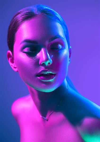 زن مدل فشن با چراغ های نئون روشن و رنگارنگ که در استودیو کلوپ شبانه عکس می گیرند پرتره دختر زیبا در UV طراحی هنری آرایش رنگارنگ در پس زمینه زنده و رنگارنگ