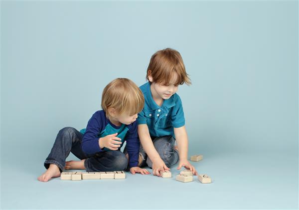 کودک کودک نوپایی که با قطارهای اسباب بازی در پیست ها زمان بازی بازی ها بازی می کند