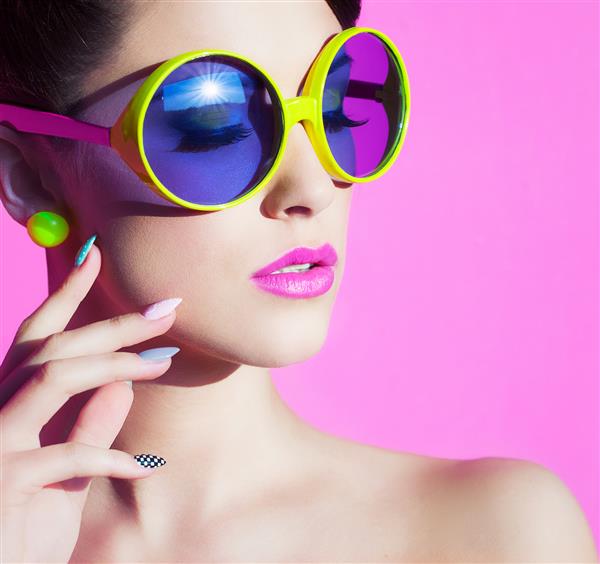 پرتره رنگارنگ تابستانی یک زن جوان جذاب با عینک آفتابی