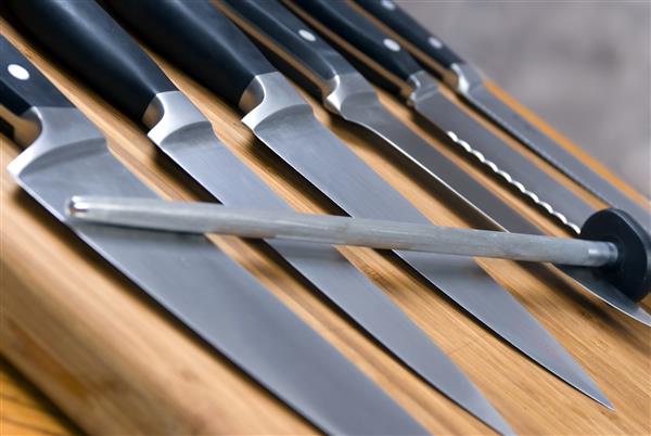 مجموعه ای از چاقوهای آشپزخانه با کیفیت بالا روی تخته برش