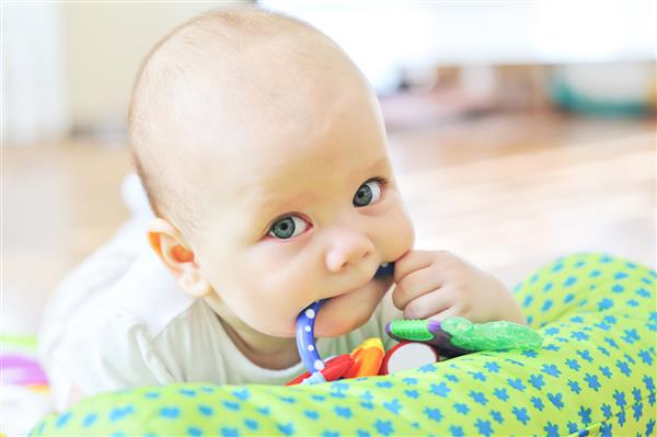 کودک با اسباب بازی در دهان