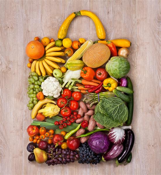 خرید غذای سالم عکاسی از غذا از کیف دستی طراح ساخته شده از میوه ها و سبزیجات مختلف روی میز چوبی