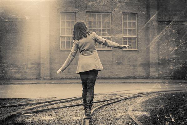 دختری که در راه آهن قدم می زند برش خورده در عکس های سیاه و سفید رنگی