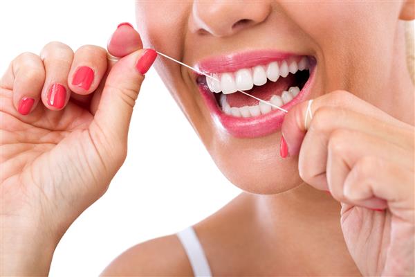 گرگرفتگی دندان - زنی که نخ دندان می کشد و لبخند می زند