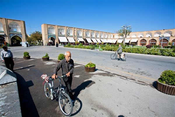 اصفهان ایران بزرگسال با دوچرخه سواری در میدان امام با بناهای تاریخی در 14 اکتبر 2014