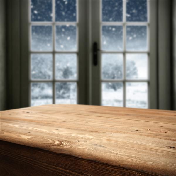 میز چوبی بزرگ قهوه ای و پنجره ای از زمان زمستان