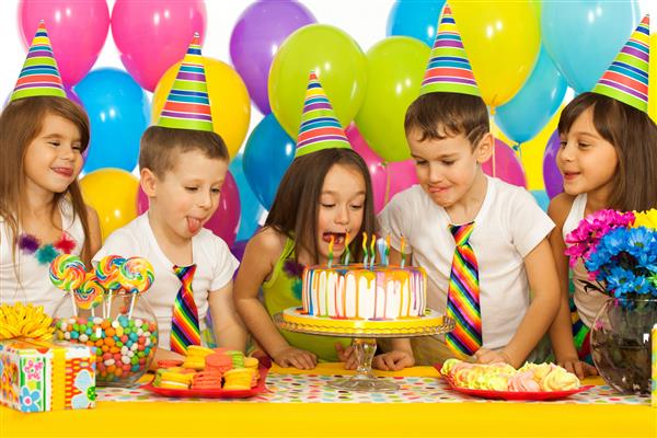 گروهی از بچه های کوچک شاد با کیک در جشن تولد مفهوم تعطیلات