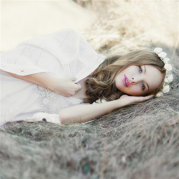 مدل زن بور زیبا که در بهار در مزرعه ای خوابیده است