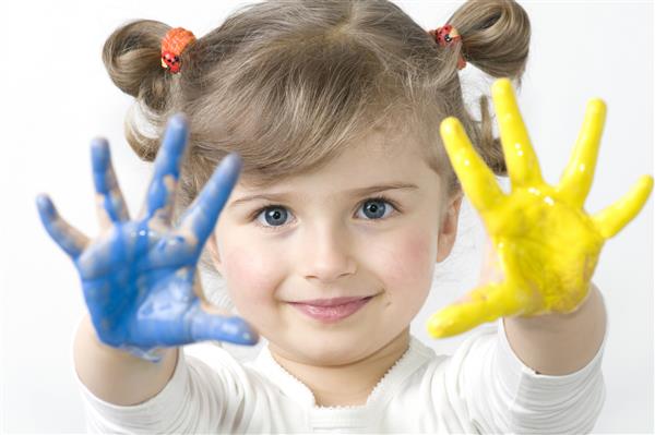 دختر کوچک با رنگ ها بازی می کند