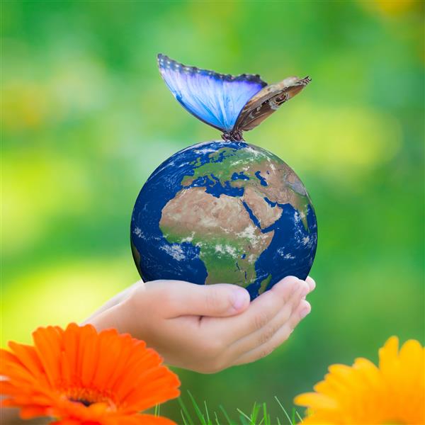 کودکی که سیاره زمین را با پروانه آبی در دست دارد و در پس زمینه تاریک سبز در دست دارد روز زمین مفهوم تعطیلات بهاری عناصر این تصویر تهیه شده توسط ناسا