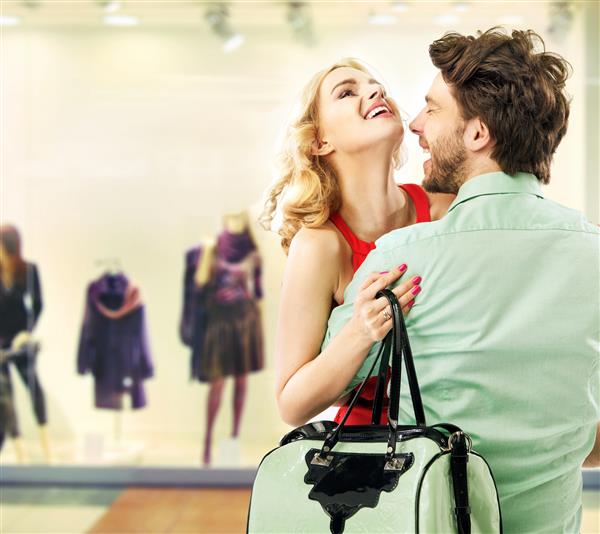 زن و شوهر خندان در یک مرکز خرید