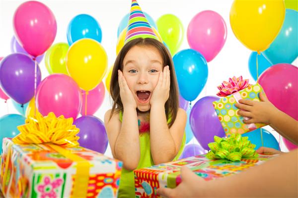 دختر بچه کوچک شاد در هنگام جشن تولد هدیه می گیرد تعطیلات مفهوم تولد
