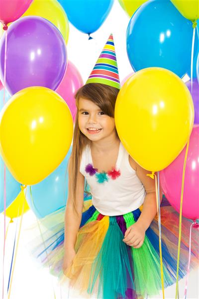 دختر بچه کوچک مبارک با بادکنک های رنگارنگ در جشن تولد تعطیلات مفهوم تولد