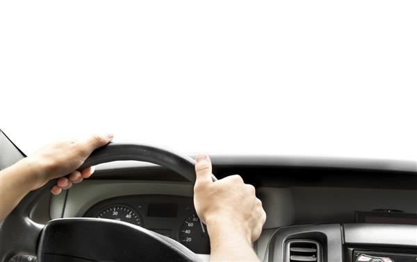 دستان یک راننده روی فرمان اتومبیل مینی ون در جاده آسفالته