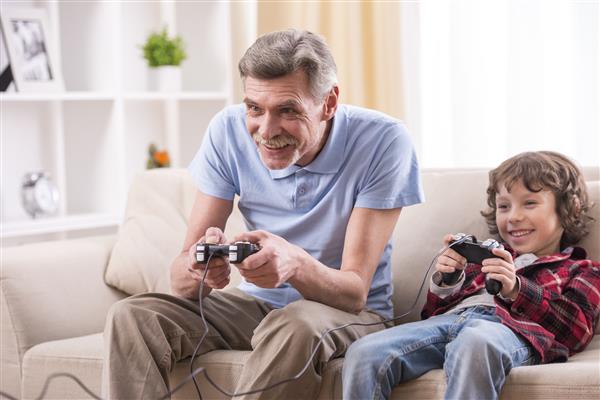 پدربزرگ و نوه در خانه مشغول بازی های ویدیویی هستند
