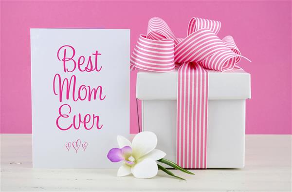 روز مادر و هدیه صورتی و سفید روز مادر با کارت تبریک بهترین مادر همیشه بر روی میز چوبی مضطرب و شیک سفید مبارک