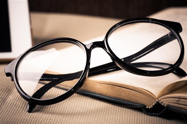 کتاب مفهوم و رایانه لوحی و عینک چشم روی میز
