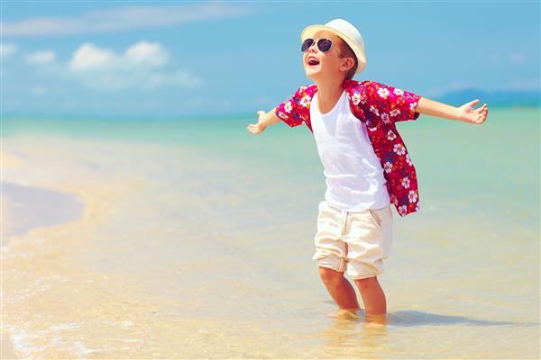 پسر بچه خوشگل مد روز از زندگی در ساحل تابستان لذت می برد