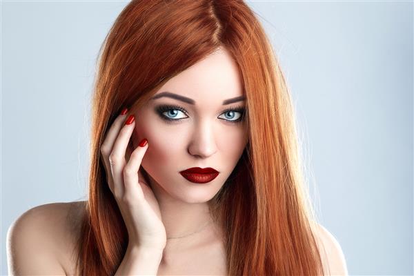 مدل زیبایی مد زن بلند مو قرمز لب و ناخن مات قرمز چشمهای آبی