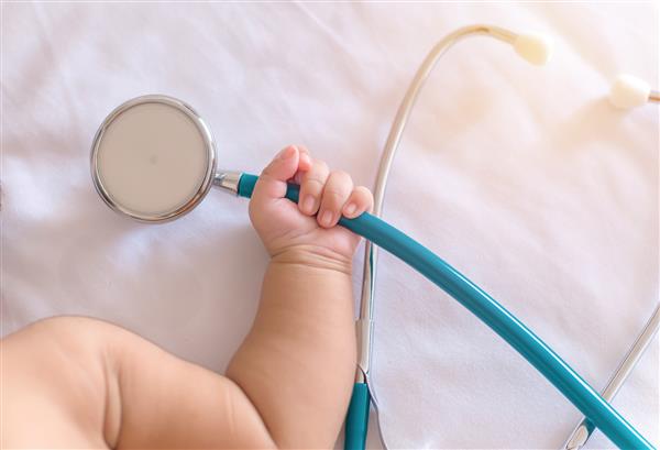 ابزار پزشکی استتوسکوپ در دست دختر نوزاد تازه متولد شده
